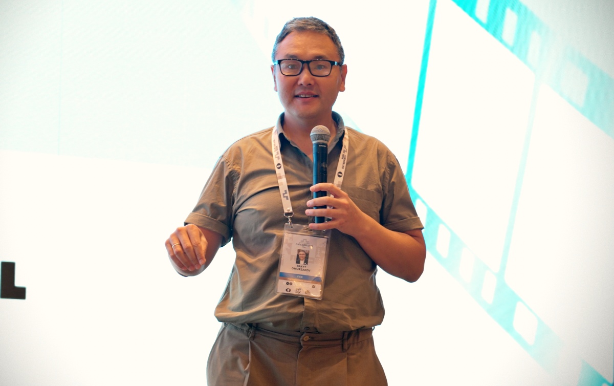 一位嘉宾在舞台上持话筒发言。
